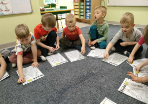 Dzieci z grupy "Pszczółek" przyklejają znaczki "EKO" na kartach pracy.