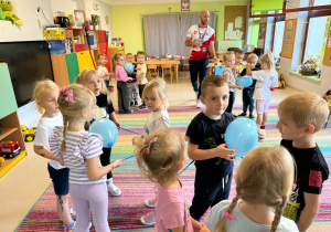 Dzieci biorą udział w zabawach ruchowych proponowanych przez trenera.