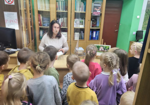 Bibliotekarka opowiada dzieciom o swojej pracy.