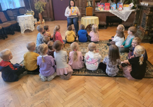 Dzieci z grupy III słuchają bajki „Kubuś Puchatek. Wszyscy moi przyjaciele”, czytanej przez panią bibliotekarkę.