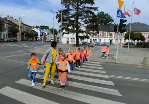 Dzieci z Grupy Kaczuszki przechodzą przez przejście dla pieszych.