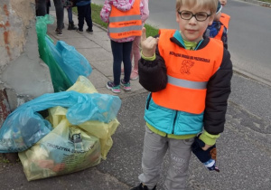 Dzieci zbierają śmieci do odpowiednich worków.