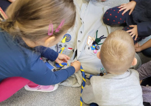 Dzieci z grupy "Biedronki" oglądają mundur harcerski.