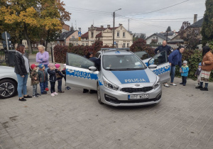 Dzieci z grup młodszych wraz z ciociami oglądają radiowóz policyjny