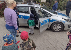 Maluszki oglądają samochód policyjny.
