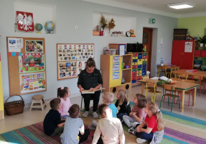 Babcia jednego z przedszkolaków czyta bajkę dzieciom z grupy "Kaczuszki".