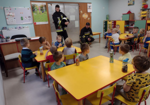 Dzieci z grupy "Pszczółek" w trakcie pogadanki o zachowaniu w sytuacji nagłego zagrożenia, prowadzonej przez strażaków.