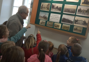 Dzieci z grupy "Kaczuszki" wraz z panem prowadzącym oglądają Ozorków na starych fotografiach i pocztówkach.