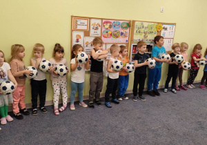 Dzieci z grupy "Biedronek" trzymają piłki.