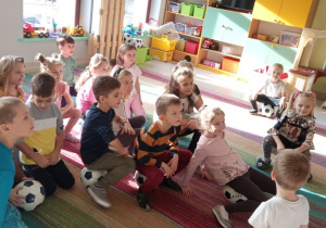 Dzieci z grupy "Kaczuszek" słuchają pana prowadzącego zajęcia.