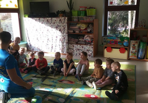 Dzieci z grupy "Motylków" słuchają pana prowadzącego zajęcia.