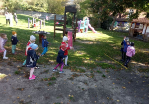 Dzieci z grupy "Kaczuszek" bawią się na ogrodzie przedszkolnym w "Raz, dwa, trzy, Baba Jaga patrzy".