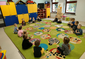 "Kopciuszek" w "Pszczółkach"-dzieci siedzą na dywanie i w trakcie czytania bajki słuchają różnych dźwięków związanych z bajką.