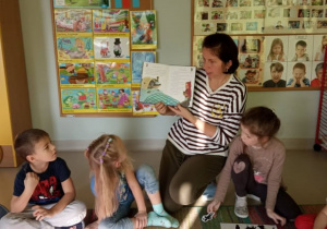"Czerwony Kapturek" w "Kaczuszkach"-Ciocia Iwonka podczas czytania dzieciom bajki. W trakcie czytania, dzieci kładą na kartce ilustracje postaci, w której w tym momencie czyta naczyciel.
