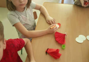 "Czerwony Kapturek" w "Kaczuszkach"-dzieci podczas wykonywania pracy plastycznej, polegającej na stworzeniu czerwonego kapturka z materiałów plastycznych.