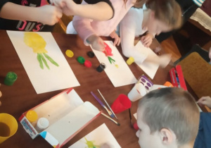 Kilkoro dzieci z "Kaczuszek" maluje swój obraz.