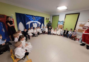 Dzieci z grupy "Biedronek" podczas Uroczystości Choinkowej. Na zdjęciu obecna jest ciocia Dorotka oraz Święty Mikołaj.