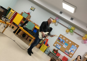 Pan Bogdan prezentuje dzieciom gitarę elektryczną.