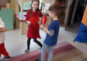 Dwoje dzieci z grupy Kaczuszek na dywanie podczas zabawy do piosenki "Serduszko przyjaźni".