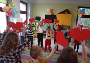 Dzieci z grupy Kaczuszek na dywanie podczas zabawy do piosenki "Serduszko przyjaźni".