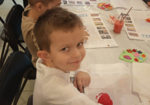 Chłopiec z grupy "Kaczuszki" pozuje do zdjęcia podczas malowania gipsowego serduszka.