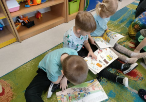 Dzieci podczas oglądania książeczek a także wyszukiwania ukrytych zadań.
