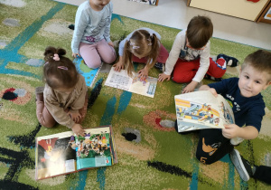 Dzieci podczas oglądania książeczek a także wyszukiwania ukrytych zadań.