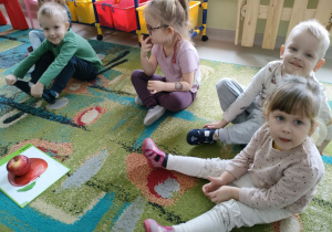 Kilkoro chętnych dzieci z grupy "Motylków" na dywanie podczas próbowania cytrynki.