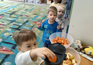 Dzieci z grupy "Motylków" podczas przygotowania naturalnego soku jabłkowo-marchewkowego z dodatkiem cytryny za pomocą sokowirówki.
