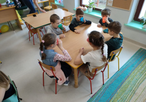 Kilkoro dzieci z grupy "Kaczuszek" przy stoliku podczas degustacji przygotowanego, naturalnego soku.