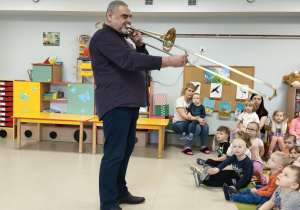 P. Sławek prezentuje dzieciom dźwięk puzonu.