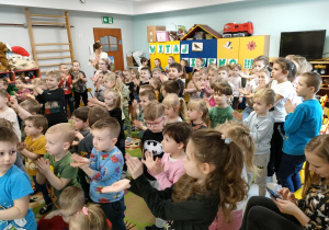 Dzieci z całego przedszkola podczas zabawy ruchowej przy melodii "Baby Shark" pochodzącej z puzonu.