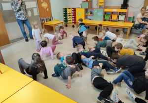 Przedszkolaki podczas zabawy ruchowej, polegającej na naśladowaniu zwierząt.