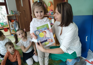 Ciocia Iwonka wręcza Poli upominek oraz dyplom za udział w konkursie "Wielkanocna ozdoba".
