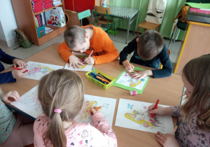 Kilkoro dzieci z grupy Kaczuszek koloruje szablon Pani Wiosny.