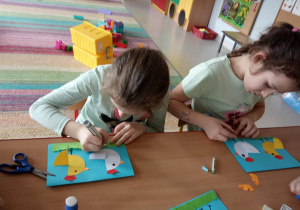 Dwie dziewczynki z Kaczuszek wykonują kartki świąteczne dla podopiecznych Domu Pomocy Społecznej.