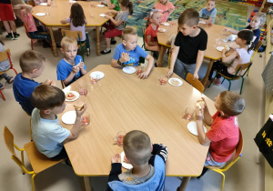 Kilkoro dzieci przy stole w trakcie kolacji.