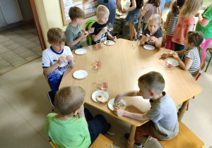 Kilkoro dzieci przy stole w trakcie kolacji.