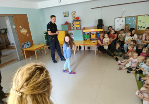 Kornelia prezentuje dzieciom, jak należy się zachować podczas przechodzenia przez pasy.