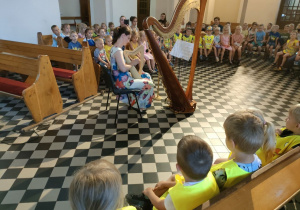 Pani Joanna Jakubowska gra na małej harfie.