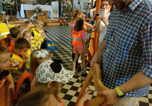 Dzieci z grupy Kaczuszek grają na małej harfie.