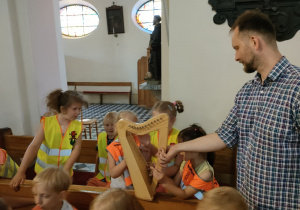 Dzieci z grupy Skrzatów grają na małej harfie.