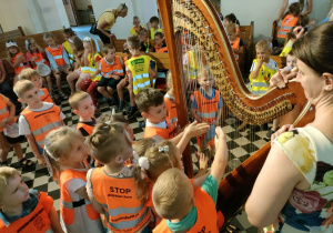 Dzieci z grupy Biedronek grają na wielkiej harfie.