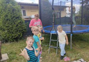 Dzieci z Biedronek pod okiem cioci Ani korzystają z trampoliny.