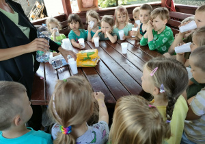 Dzieci z Biedronek piją wodę w altance.