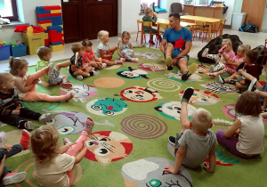 Dzieci z grupy Motylków podczas rozgrzewki na dywanie.