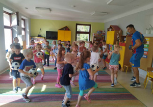 Dzieci z grupy Skrzatów podczas zabawy ruchowej z piłkami.