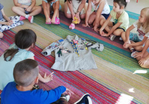 Dzieci z grupy Skrzatów słuchają Druhny i oglądają prawdziwy mundur harcerski.
