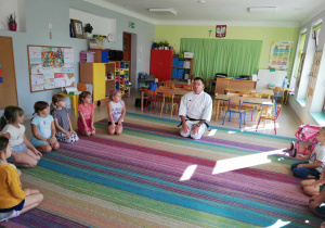 Dzieci z grupy Skrzatów wraz z senseiem podczas zajęć pokazowych karate.