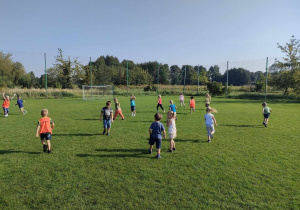 Dzieci z grupy "Pszczółek" na boisku sportowym podczas treningu piłki nożnej.